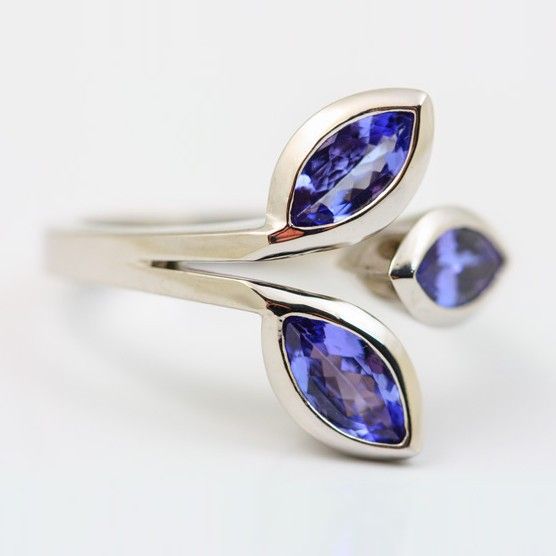 A white gold ring of three tanzanite leaves, two marquise and one pear, on a crossover band