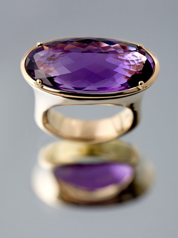 Ring with a large oval amethyst set east to west, standing on its reflection