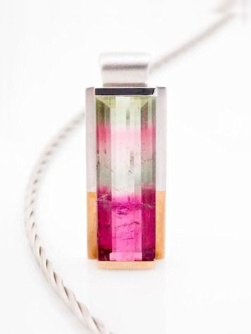A pendant of watermelon tourmaline, green over pink, in a rose and white gold frame on a twisted cord